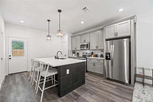 a kitchen with refrigerator cabinets and wooden floor