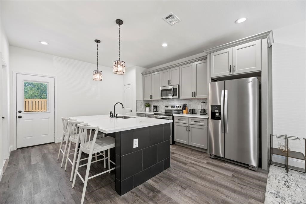 8636 Scott Street, Unit A Houston, TX 77051 - Photo 6 of 21 a kitchen with refrigerator cabinets and wooden floor