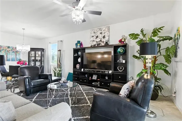 a living room with furniture a chandelier and a flat screen tv