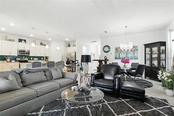 a living room with furniture kitchen and a chandelier