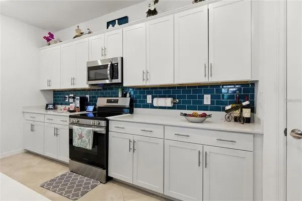 a kitchen with white cabinets and white appliances