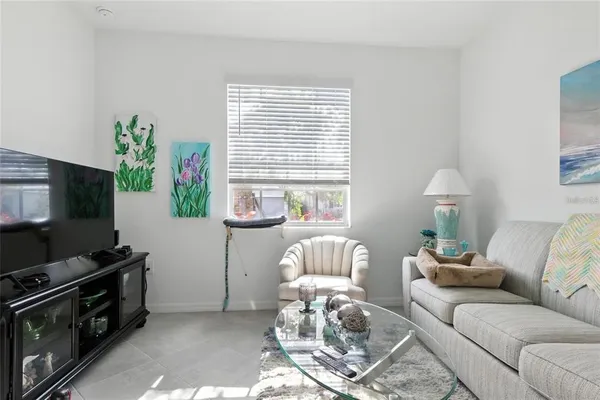 a living room with furniture a flat screen tv and a window