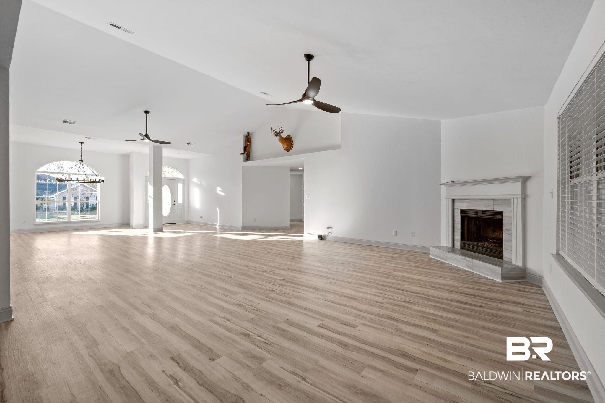 136 Destrehan Road Fairhope, AL 36532 - Photo 9 of 44 Unfurnished living room featuring ceiling fan with notable chandelier and light wood-type flooring
