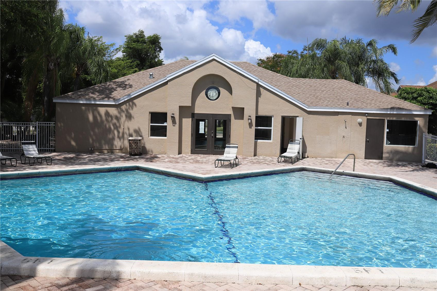 231 Southwest 113th Way, Unit 231 Pembroke Pines, FL 33025 - Photo 22 of 26 a view of a white house with a yard