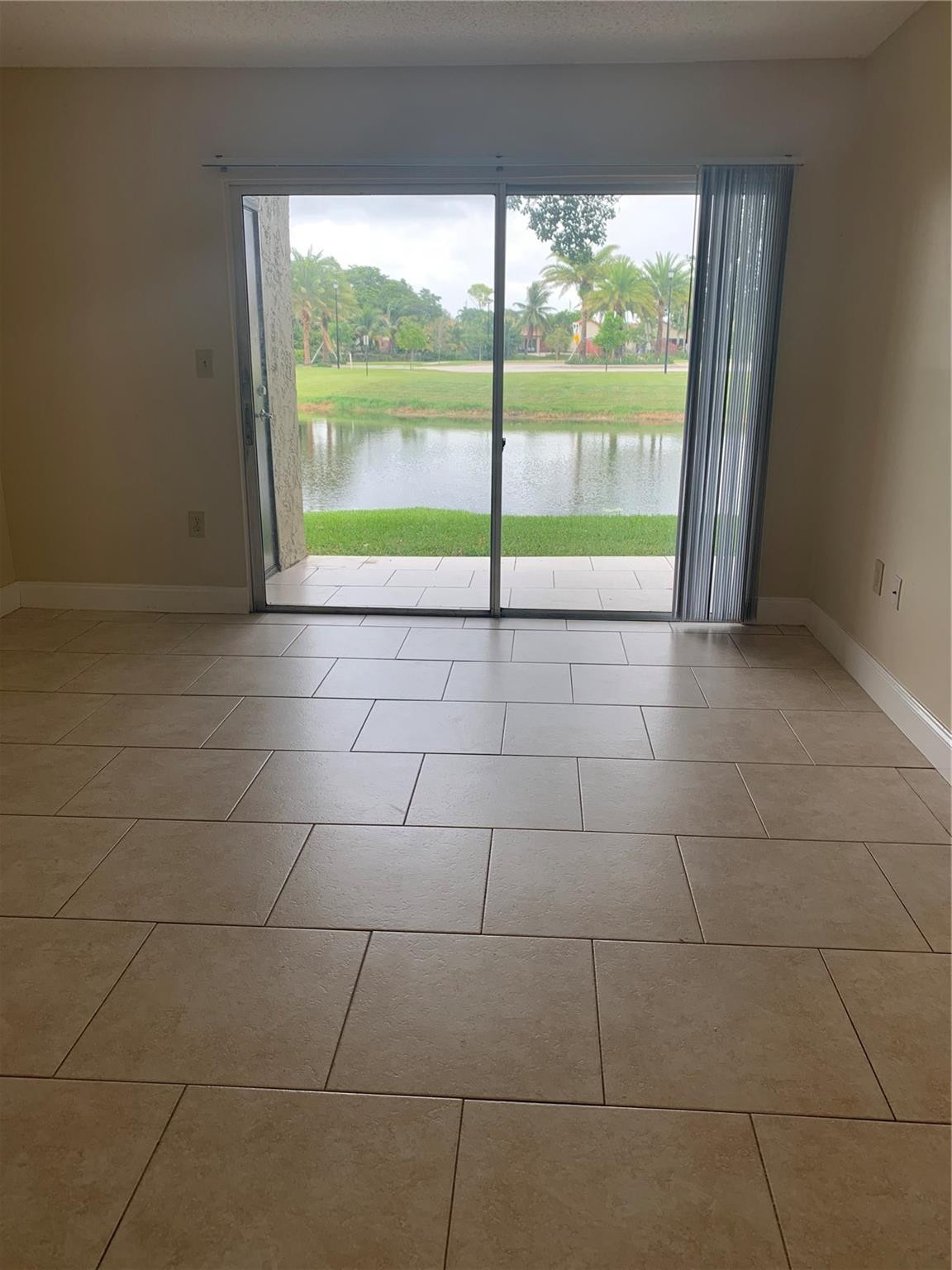 231 Southwest 113th Way, Unit 231 Pembroke Pines, FL 33025 - Photo 3 of 26 a view of an empty room with a floor to ceiling window and an outdoor view