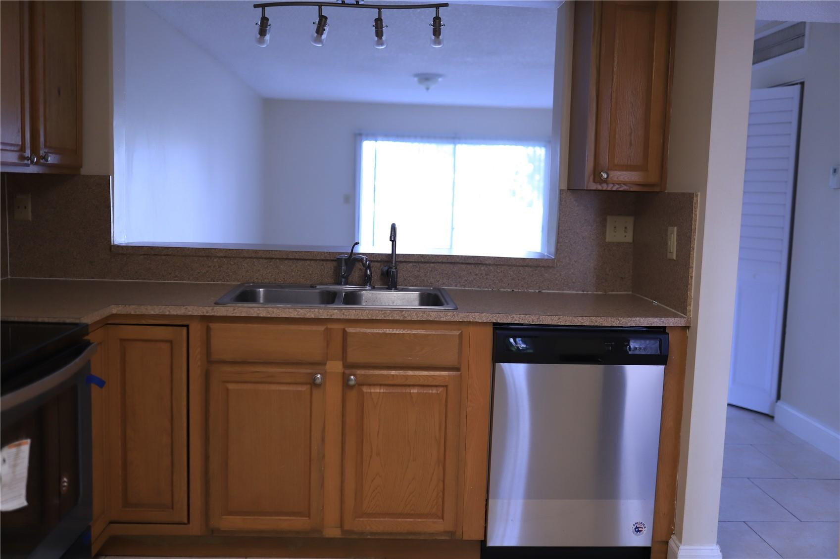 231 Southwest 113th Way, Unit 231 Pembroke Pines, FL 33025 - Photo 6 of 26 a kitchen with stainless steel appliances granite countertop wooden cabinets a stove a sink and a window