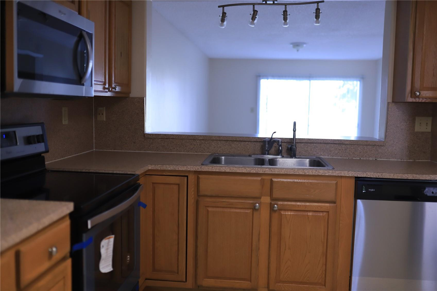 231 Southwest 113th Way, Unit 231 Pembroke Pines, FL 33025 - Photo 7 of 26 a kitchen with cabinets appliances a sink and a window