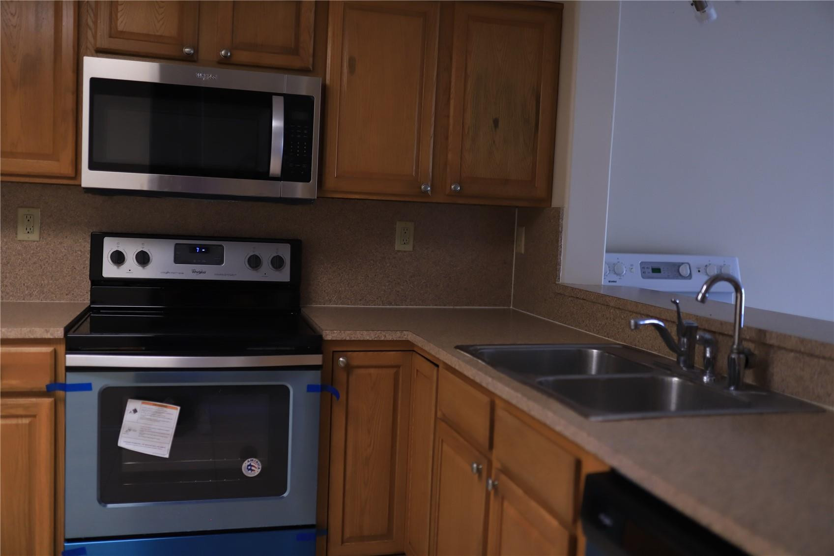 231 Southwest 113th Way, Unit 231 Pembroke Pines, FL 33025 - Photo 8 of 26 a kitchen with sink stove and microwave