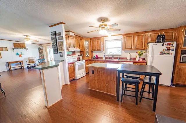 a room with stainless steel appliances a dining table wooden floor and a large window
