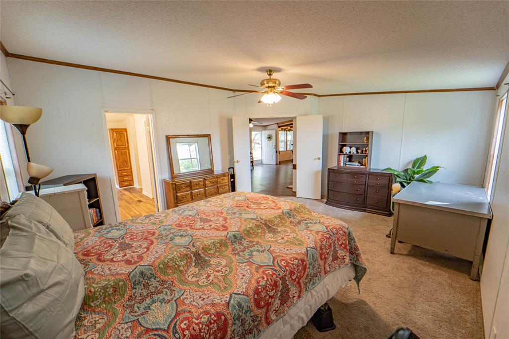 4942 County Road 206 Breckenridge, TX 76424 - Photo 22 of 40 a bedroom with a bed and a chandelier