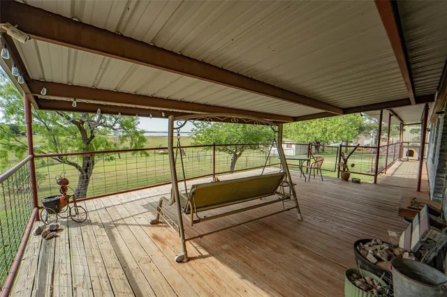 a roof deck with table and chairs and wooden floor