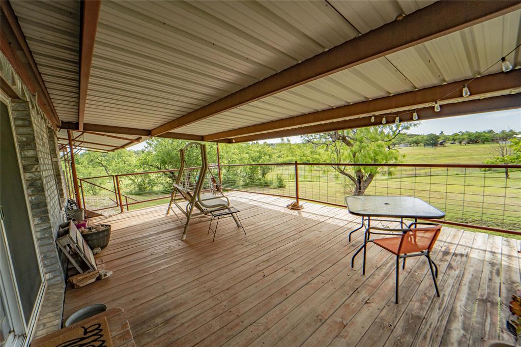 4942 County Road 206 Breckenridge, TX 76424 - Photo 34 of 40 a roof deck with table and chairs and wooden floor
