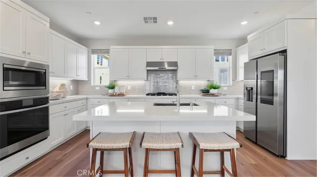 a kitchen with a table chairs refrigerator and microwave