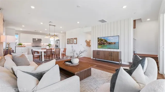 a living room with furniture kitchen view and a large window
