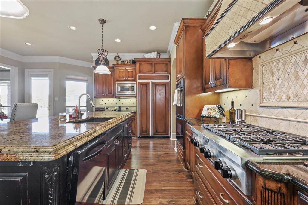 2021 Kings Pass Heath, TX 75032 - Photo 16 of 37 a kitchen with stainless steel appliances granite countertop a stove a sink dishwasher and a refrigerator