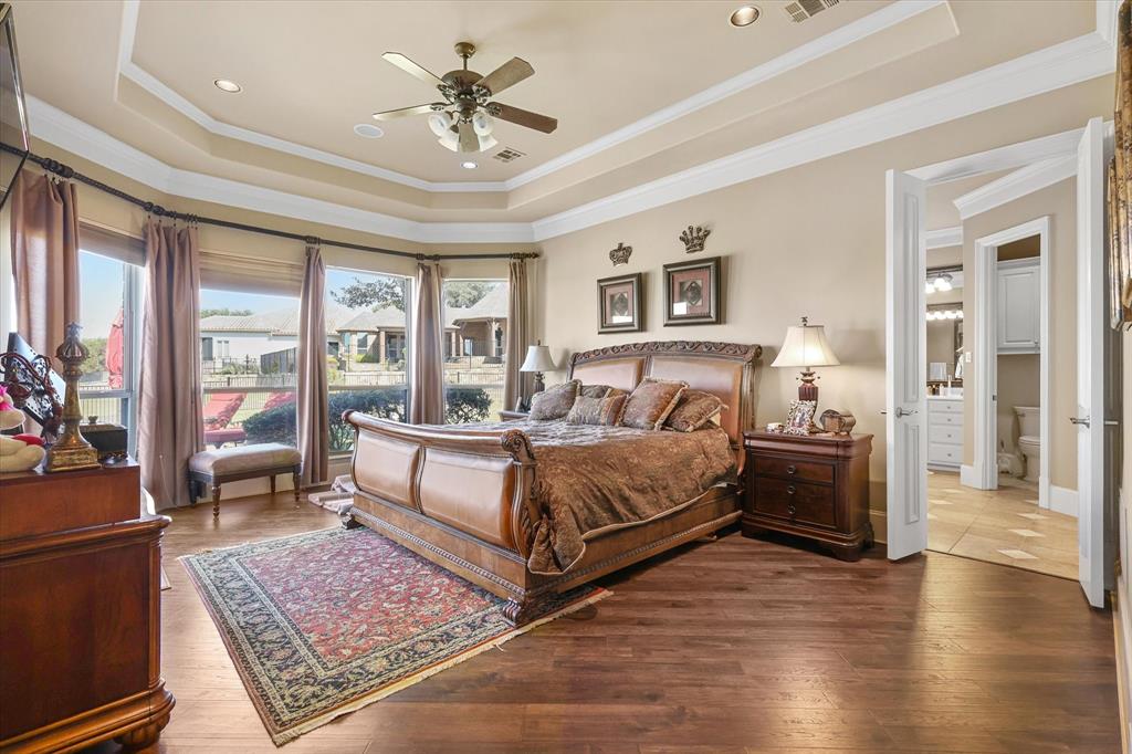 2021 Kings Pass Heath, TX 75032 - Photo 19 of 37 a spacious bedroom with a large bed a rug and windows