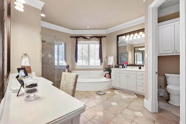 a large white bathroom with sink mirror and bathtub