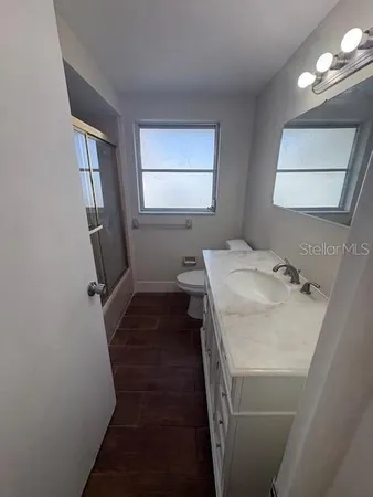 a bathroom with a sink and mirror with window