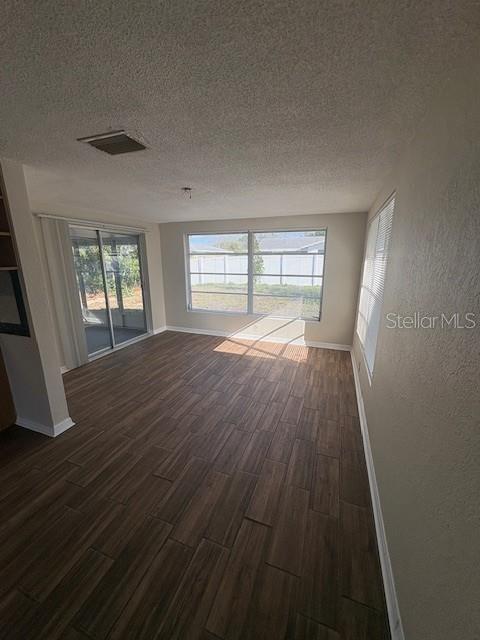 7839 Canna Drive Port Richey, FL 34668 - Photo 5 of 12 wooden floor in an empty room with a window