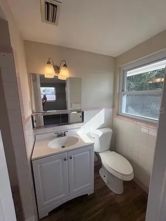a bathroom with a toilet a sink and mirror