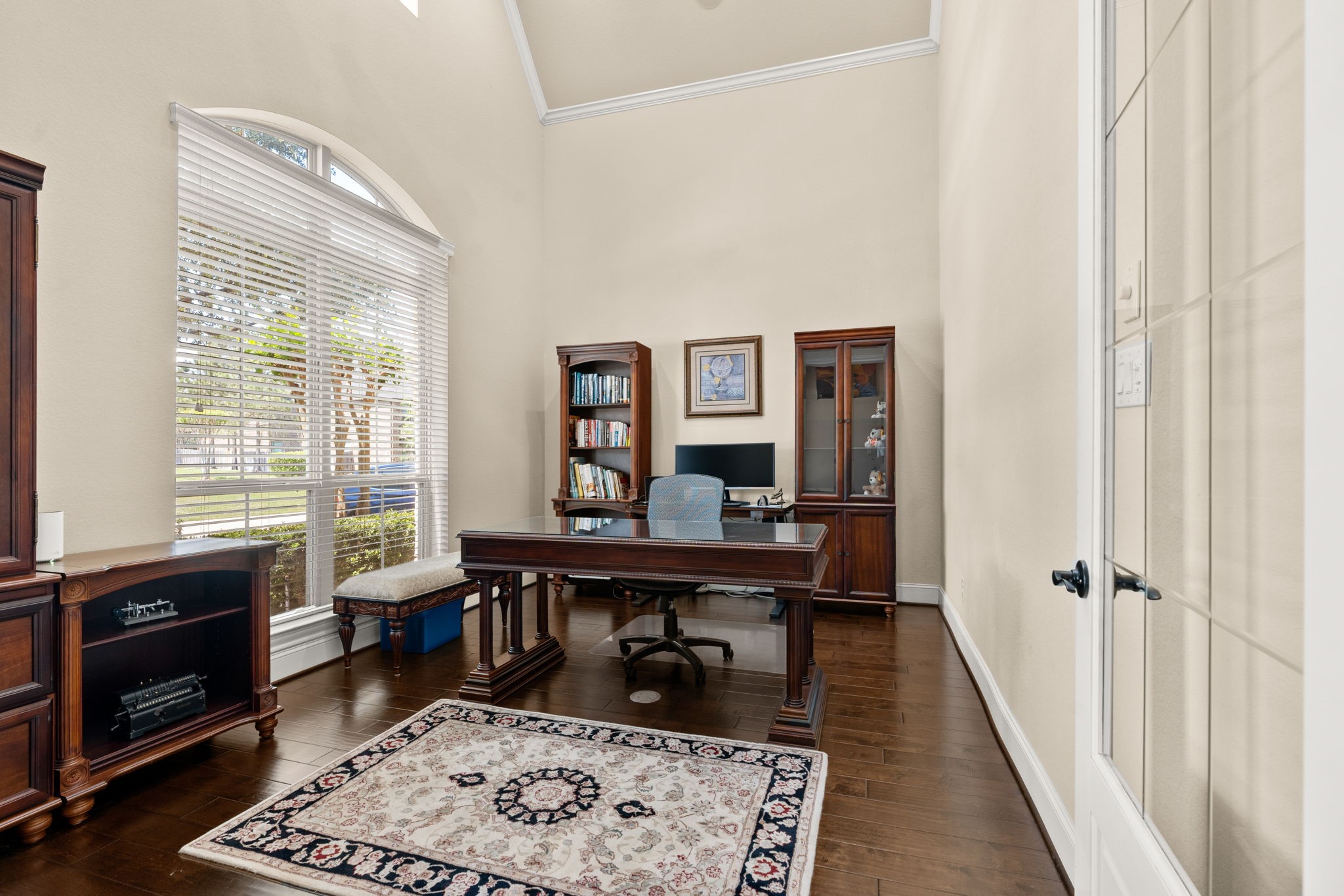 107 Elk Run Court Conroe, TX 77384 - Photo 10 of 50 Home office features high ceilings, warm wood flooring, and abundant natural light streaming through large windows, creating an inspiring and productive workspace.