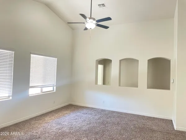 a view of a big room with wooden floor and windows