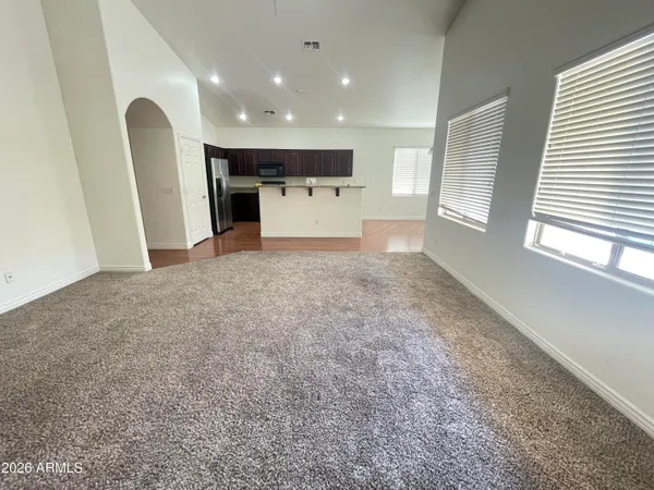a view of a kitchen with a stove cabinets a ceiling fan and wooden floor