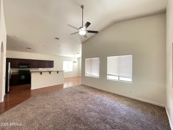 a view of a kitchen with a stove cabinets a ceiling fan and wooden floor