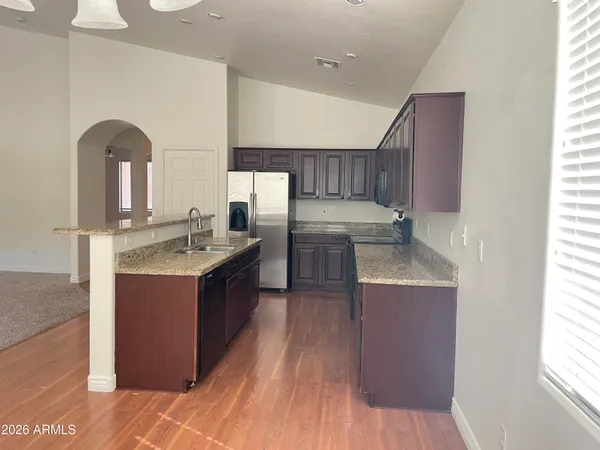 a kitchen with kitchen island granite countertop wooden cabinets a sink and dishwasher