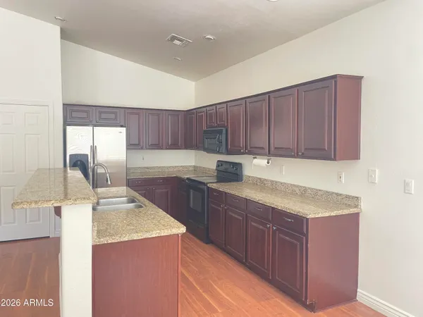 a kitchen with kitchen island granite countertop wooden cabinets a sink and dishwasher