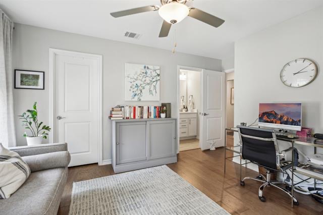 332 Adams Street Georgetown, TX 78628 - Photo 18 of 37 An inviting room boasts rich wood flooring and a modern ceiling fan, creating a comfortable living or working space.