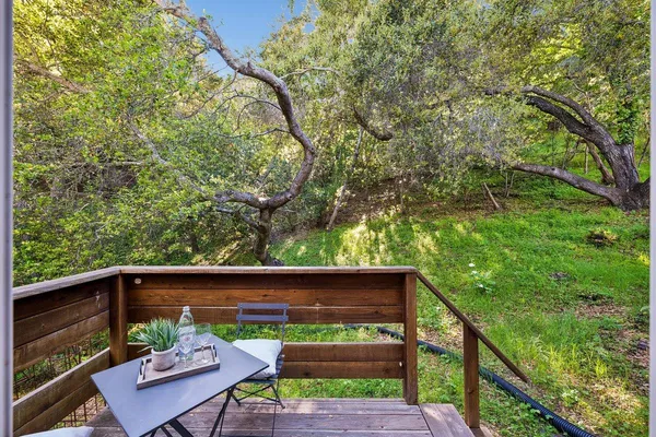 a view of yard from deck with patio