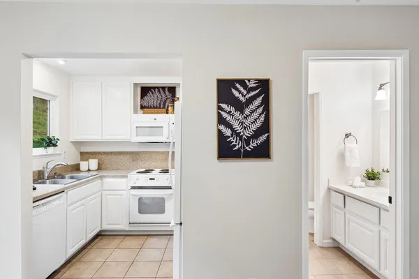 a kitchen with white cabinets and white appliances