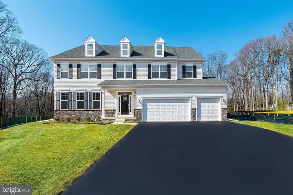 a front view of a house with a garden and yard