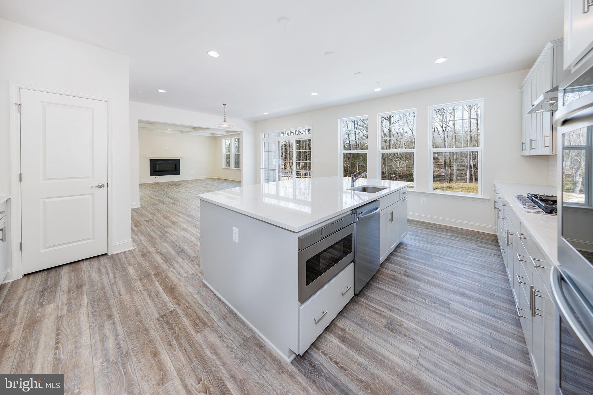 15719 Henrietta Drive Accokeek, MD 20607 - Photo 27 of 48 a large white kitchen with wooden floors and wide window