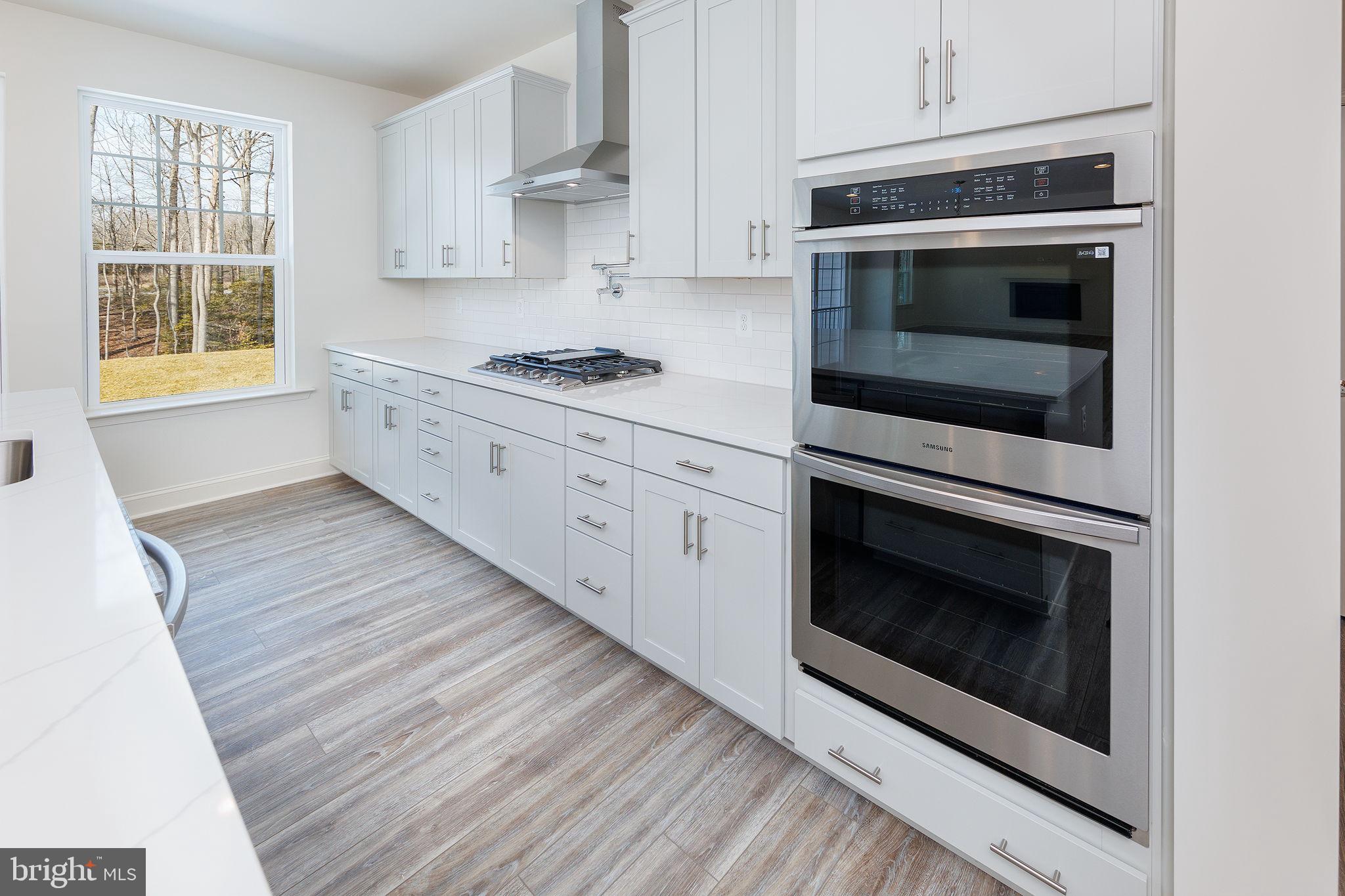 15719 Henrietta Drive Accokeek, MD 20607 - Photo 29 of 48 a kitchen with stainless steel appliances white cabinets and a stove top oven