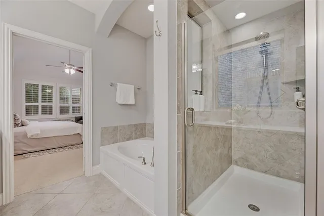 a bathroom with a tub shower and bedroom