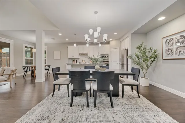 a dining room with furniture a chandelier and wooden floor