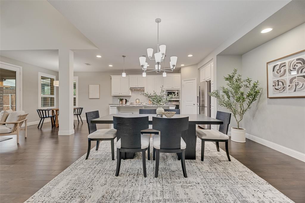 1508 Cherry Blossom Lane Prosper, TX 75078 - Photo 3 of 40 a dining room with furniture a chandelier and wooden floor