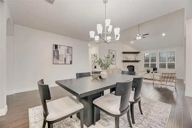 a view of a dining room with furniture a chandelier and wooden floor
