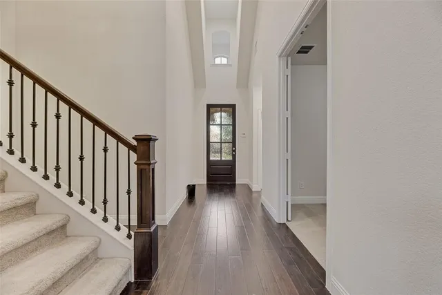 a view of a hallway with wooden floor and staircase
