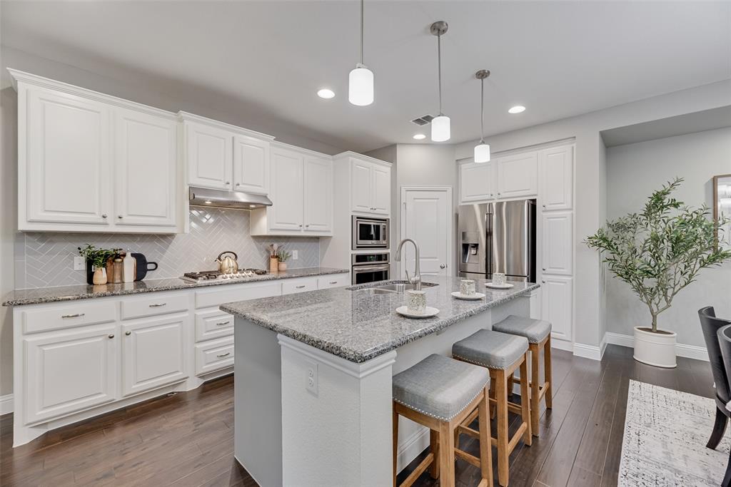 1508 Cherry Blossom Lane Prosper, TX 75078 - Photo 9 of 40 a kitchen with kitchen island granite countertop a sink center island and cabinets
