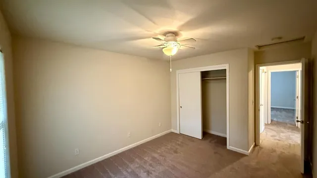 an empty room with a ceiling fan and a fan