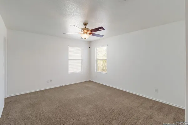 an empty room with a window and a fan