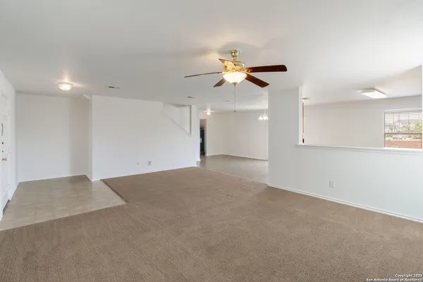 an empty room with a window and a ceiling fan