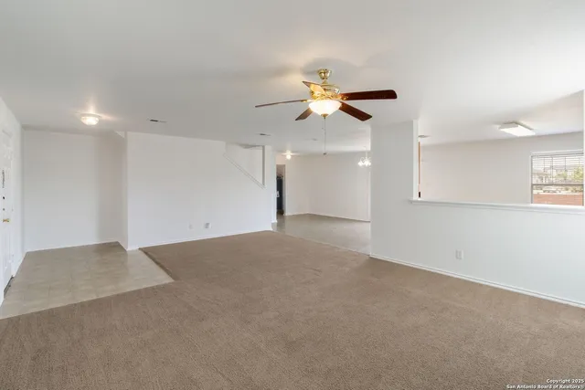 an empty room with a window and a ceiling fan