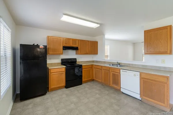 a kitchen with granite countertop a refrigerator and a stove