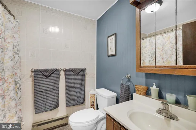 a bathroom with a toilet a sink and mirror