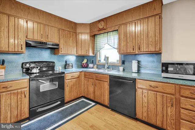 a kitchen with granite countertop wooden cabinets stainless steel appliances and a window