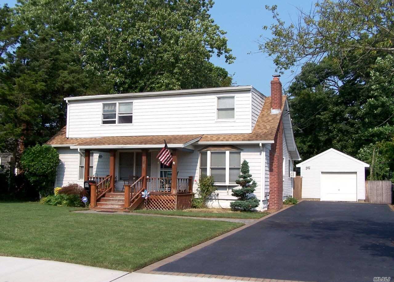 a view of a white house with large windows and a table and chairs